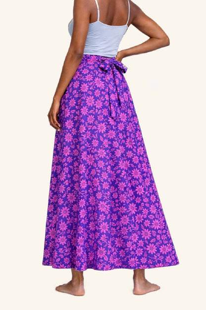 Person wearing a purple floral skirt on a white background